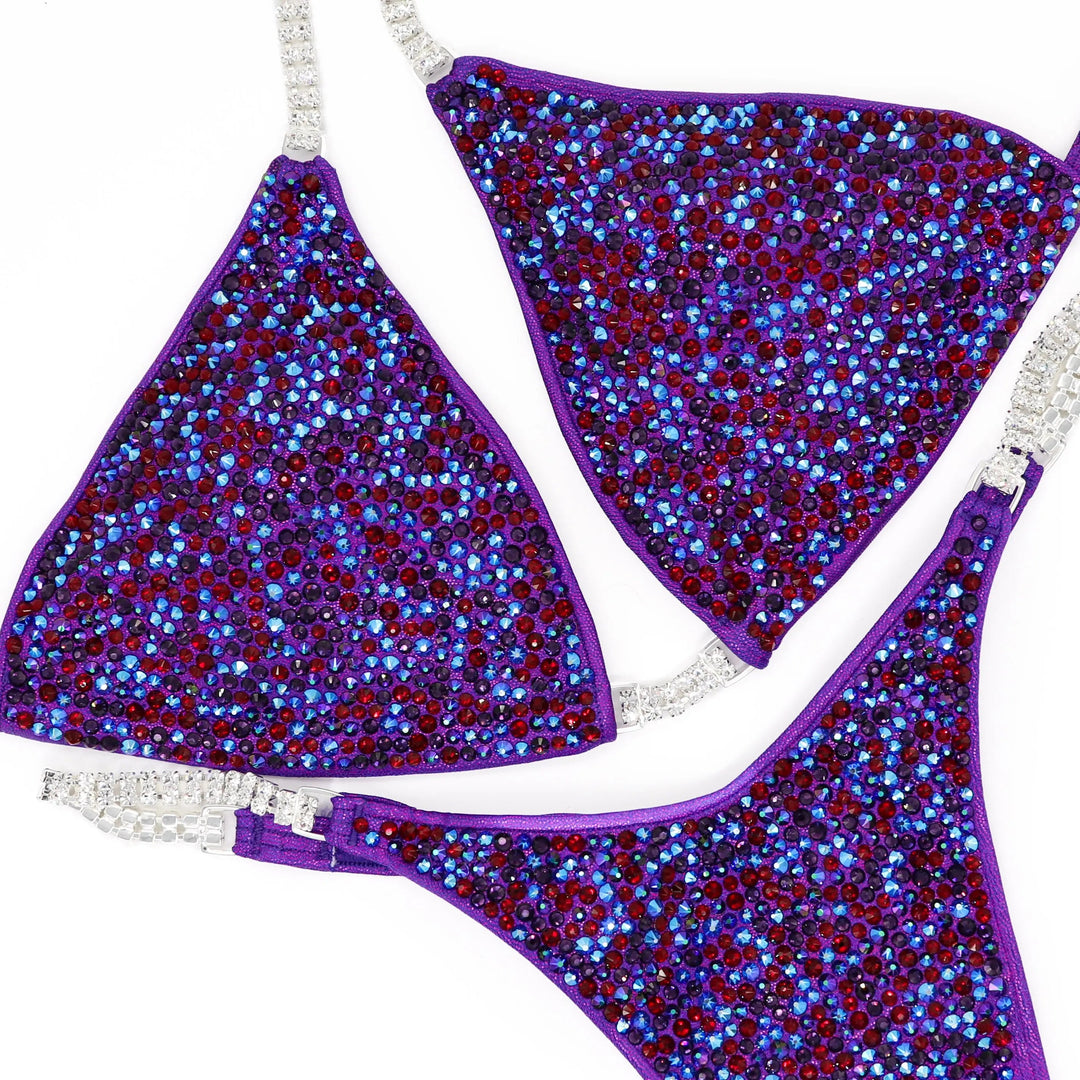 Unleash fierce elegance with Kimber's Purple Heat Radiance! A purple suit with a pop of Siam red crystals for a fiery, one-of-a-kind look. 🔥💜✨ #Bodybuilding #CrystalSuit #PurpleHeat #FieryElegance