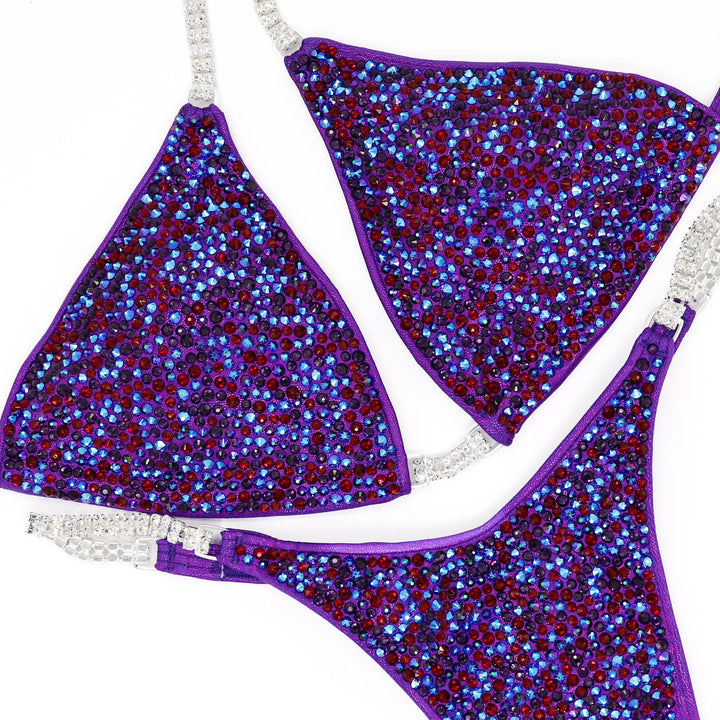 Unleash fierce elegance with Kimber's Purple Heat Radiance! A purple suit with a pop of Siam red crystals for a fiery, one-of-a-kind look. 🔥💜✨ #Bodybuilding #CrystalSuit #PurpleHeat #FieryElegance