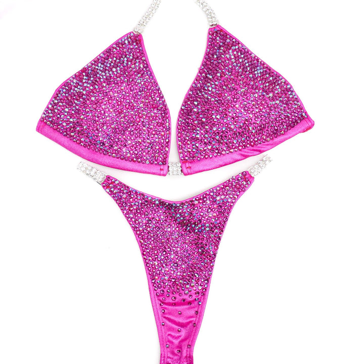 Get ready to dazzle with Lucia's Pink Radiance! 💖 Designed by Lucia Malavaze, this vibrant pink suit adorned with fuchsia crystals exudes confidence on stage. 💪✨ #Bodybuilding #CompetitionSuit #PinkRadiance 🏋️‍♀️