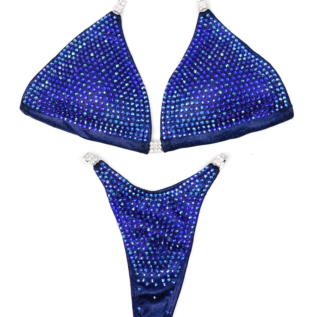 Introducing Lucia's Sapphire Trinity! 💎 Dive into elegance with this dark blue suit, featuring a captivating gradient from light to dark and back. 🌊 Designed by Lucia Malavaze for a truly unique stage presence. #Bodybuilding #CompetitionSuit #SapphireTrinity 🏋️‍♀️✨