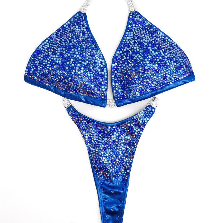 "Get ready to shine with Mary Ann's Royal Radiance! 💙✨ This electric blue bodybuilding suit, featuring captivating blue and color-changing crystals, is designed to make you stand out on stage. Created by Mary Ann Parks for champions who dare to dazzle! #BodybuildingRoyalty #StageGlow #MaryAnnParksDesign"