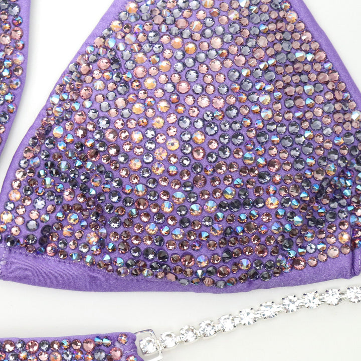 "Introducing Matte Lilac Radiance! 💜✨ Designed with Ndeye Ndour, this lilac bodybuilding suit features mesmerizing amethyst and purple crystals, ensuring you shine bright on stage. Elevate your performance and style with this stunning creation! #BodybuildingBeauty #MatteLilac #DesignerGallery"