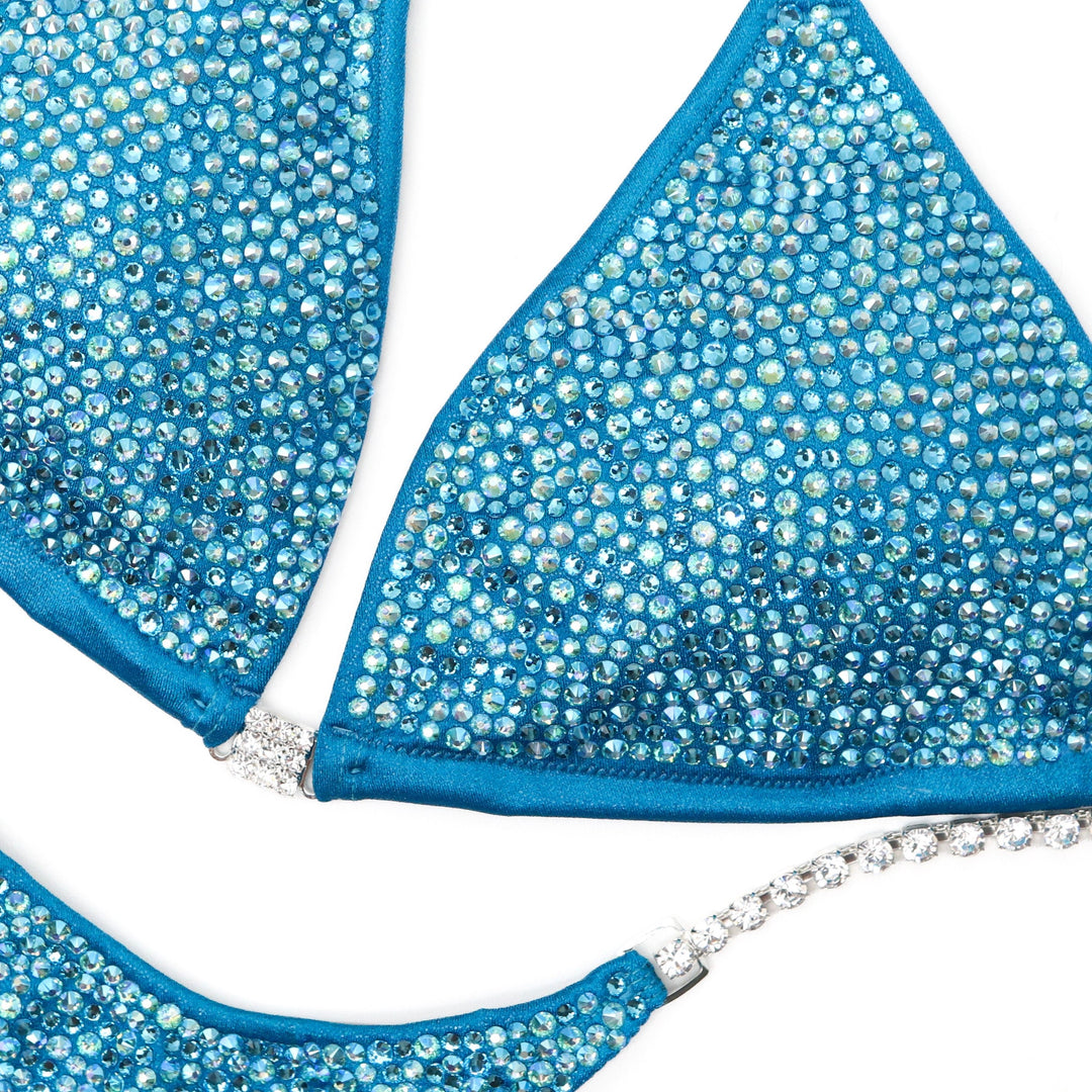 "Dive into brilliance with Natalie Matthew's Aqua Ocean Radiance! 🌊💎 This hologram turquoise bodybuilding suit adorned with aqua and aqua AB crystals is your ultimate stage companion. Make waves with style! #BodybuildingGlam #AquaOcean #NatalieMatthewDesigns"