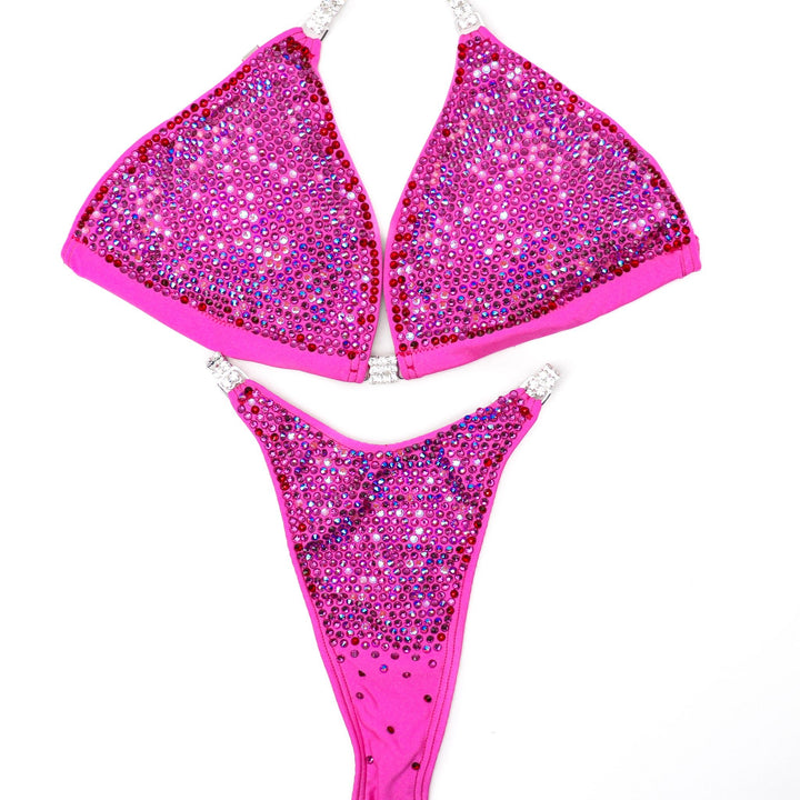 Introducing Party Pink Nova 🎉! This matte pink competition suit for female bodybuilders exudes personality with its mix of pinks, reds, and fuchsia crystals 💖. Get ready to party on stage with this vibrant attire! #Bodybuilding #CompetitionSuit #PartyPinkNova 🎀💪🎉