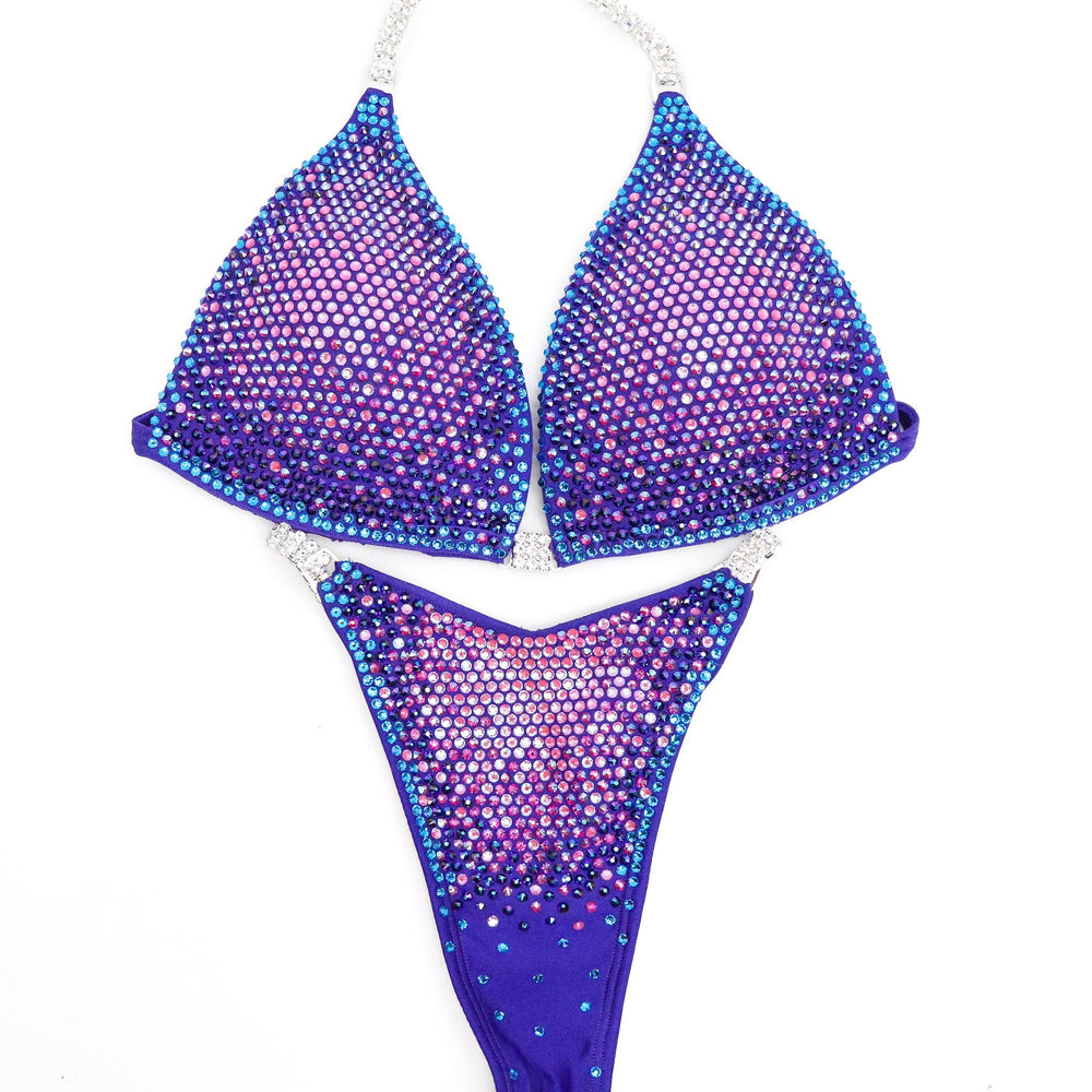 Introducing Party Purple Nova 🎉! This electric purple competition suit for female bodybuilding radiates personality with its mix of pinks, purples, and blue crystals 💜. Get ready to light up the stage with this vibrant attire! #Bodybuilding #CompetitionSuit #PartyPurpleNova 🎀💪🎉