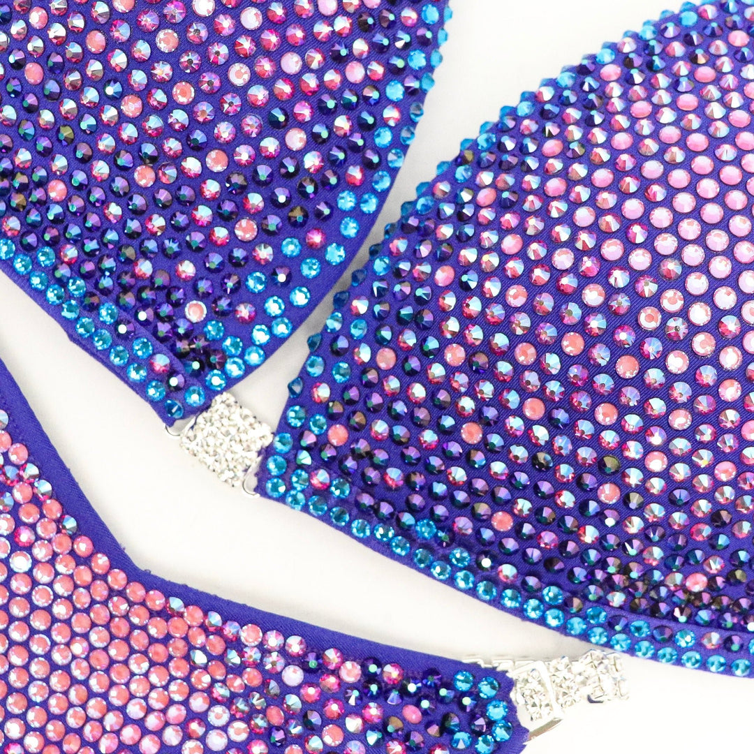 Introducing Party Purple Nova 🎉! This electric purple competition suit for female bodybuilding radiates personality with its mix of pinks, purples, and blue crystals 💜. Get ready to light up the stage with this vibrant attire! #Bodybuilding #CompetitionSuit #PartyPurpleNova 🎀💪🎉