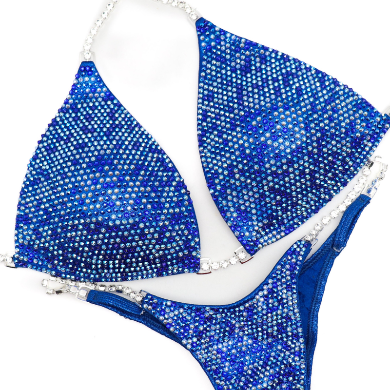 Introducing Lucia's Olympia Bound Multi Color! 💙 Shine bright on stage with this bold blue suit, intricately adorned with shimmering shades of blue crystals. ✨ Designed by Lucia Malavaze, it's your ultimate competition companion! #Bodybuilding #CompetitionSuit #OlympiaBoundMultiColor 💪👗