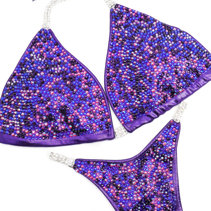 Introducing Lucia's Purple Disco Radiance! Shine like a star on stage with this eggplant suit adorned with fuchsia, sapphire, and violet crystals. 💜 Designed to make you stand out! #Bodybuilding #CompetitionSuit #PurpleDiscoRadiance 💪🌟