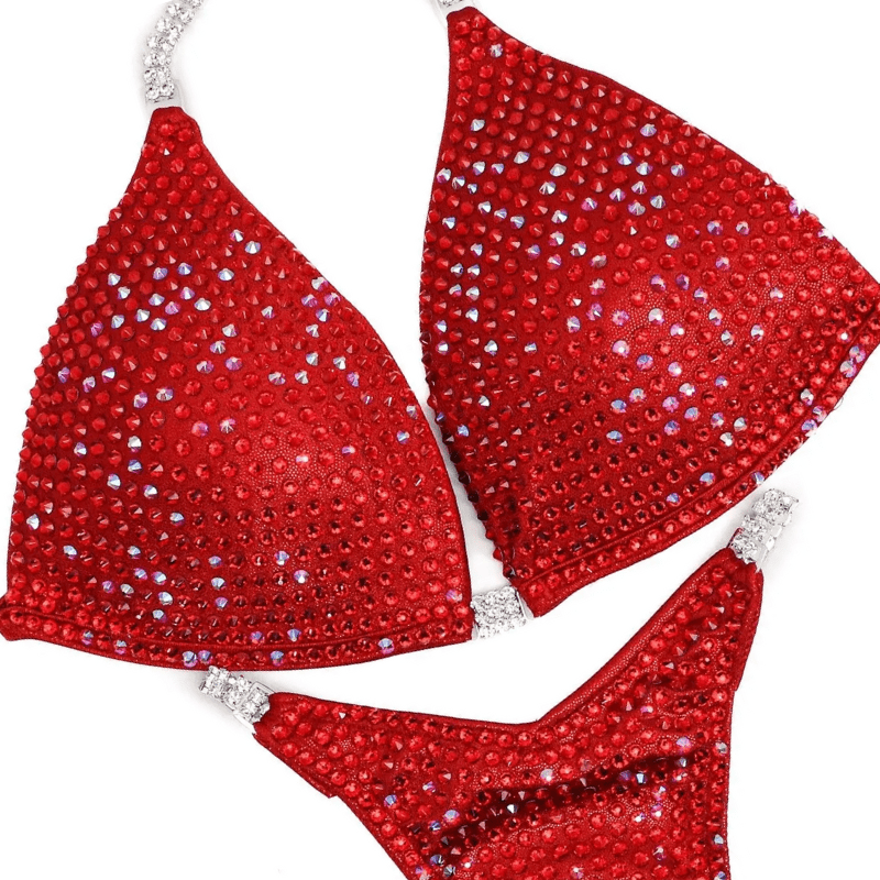Red custom bikini set adorned with sparkling crystals, designed to highlight an athlete's physique uniquely.