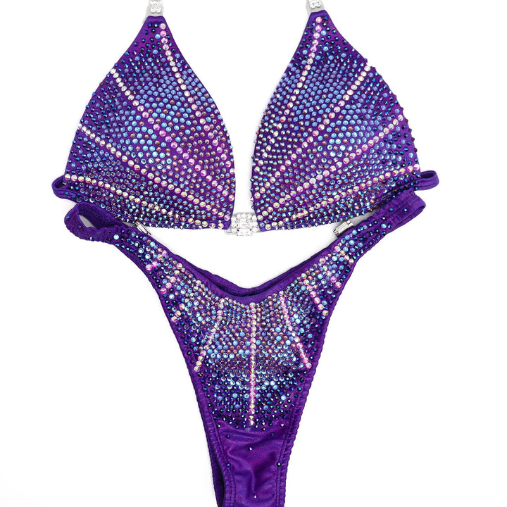 Introducing Purple Lagoon Cosmo 💜! This captivating purple competition suit features a mesmerizing design with purple and crystal burgundy crystals, ensuring you shine brightly on stage with elegance and grace ✨. #Bodybuilding #CompetitionSuit #PurpleLagoonCosmo 👙💎🌟