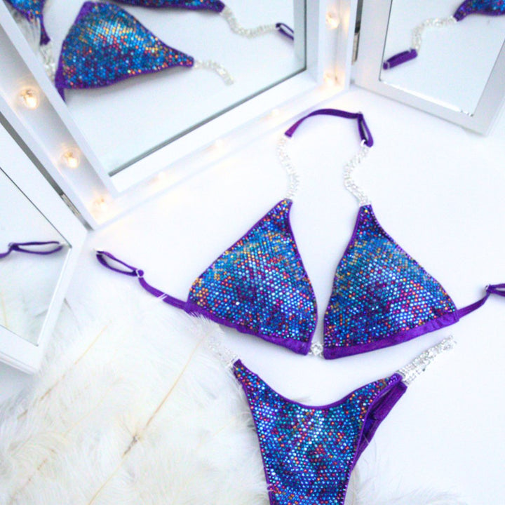 Introducing Purple Volcano Nova 🌋! This hologram purple competition suit dazzles with volcano purple and blue crystals, igniting confidence and brightness on stage. Let your inner fire shine! #Bodybuilding #CompetitionSuit #PurpleVolcanoNova 💜👙🔥