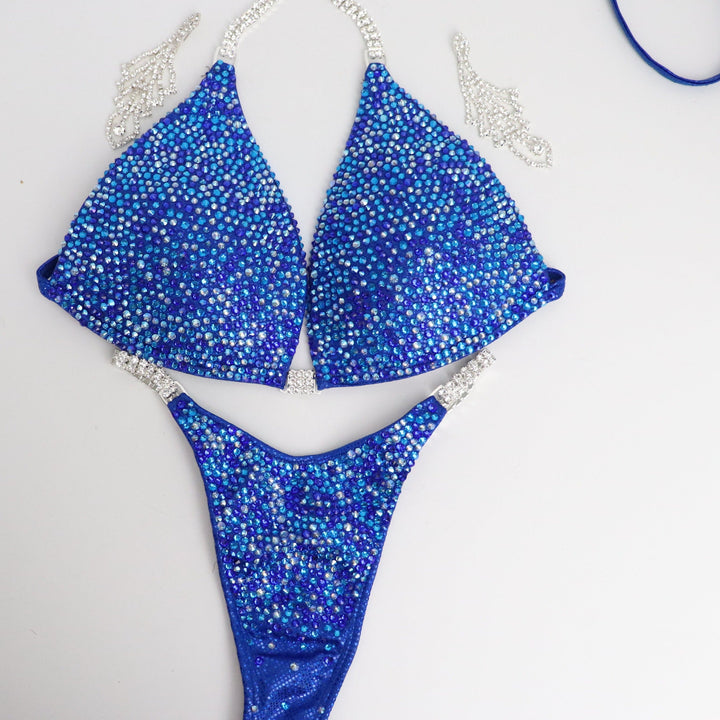 Introducing Rachel's Blue Radiance 💙! This electric blue competition suit features an array of sparkling blue crystals, flattering every skin tone and ensuring you shine like Rachel Schatz on stage. #Bodybuilding #CompetitionSuit #BlueRadiance 💎👙✨