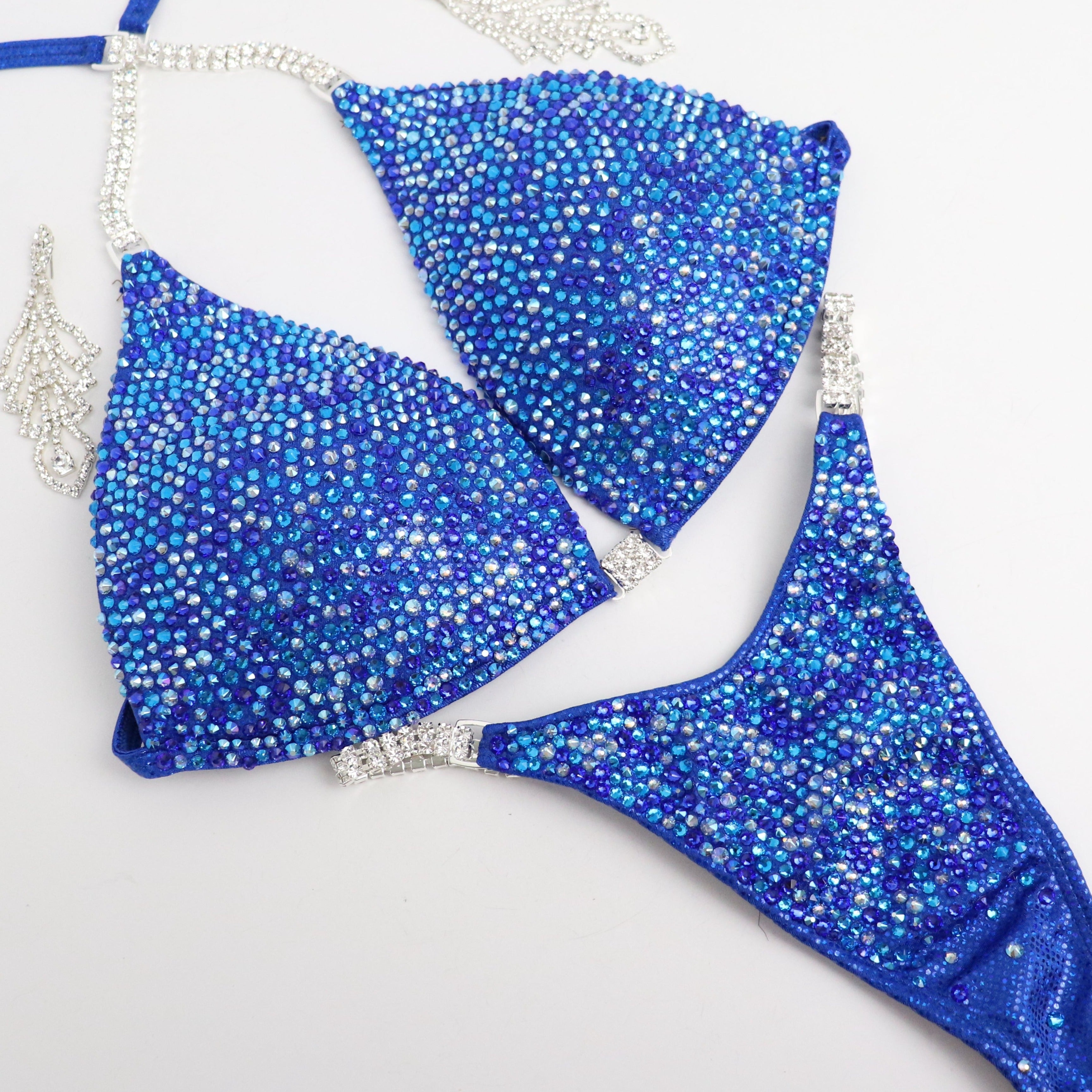 Introducing Rachel's Blue Radiance 💙! This electric blue competition suit features an array of sparkling blue crystals, flattering every skin tone and ensuring you shine like Rachel Schatz on stage. #Bodybuilding #CompetitionSuit #BlueRadiance 💎👙✨