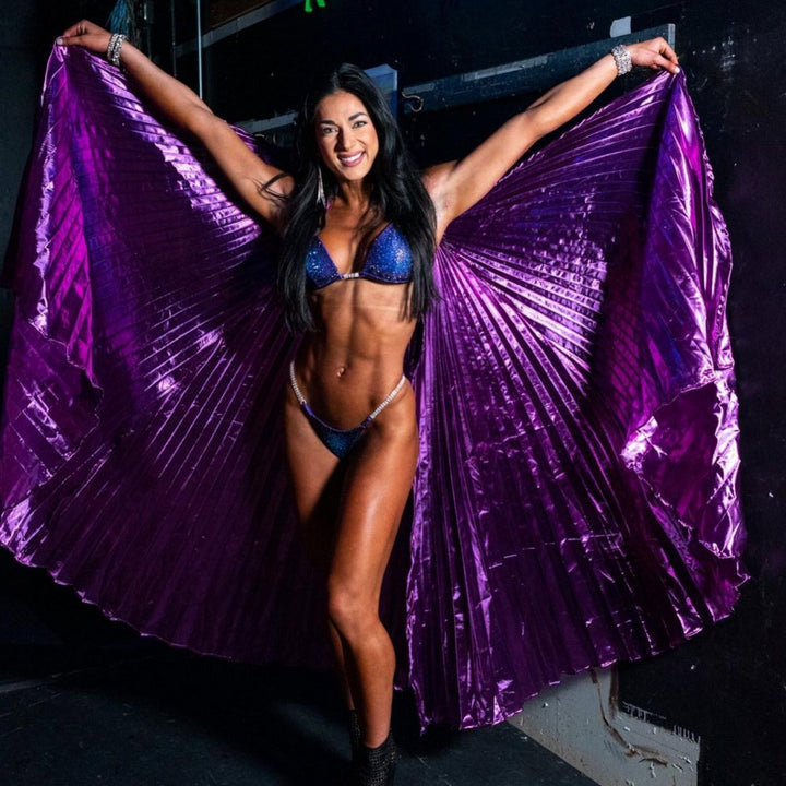 Step into the spotlight with Savana's Midnight Sunset Nova! 🌅✨ This electrifying purple suit features a plethora of blue and violet crystals, meticulously crafted in collaboration with Savana Sharp. Perfect for female bodybuilding competitions, it radiates strength and sophistication on stage. 💜💎 #BodybuildingFashion #MidnightSunsetNova #FitnessCompetition