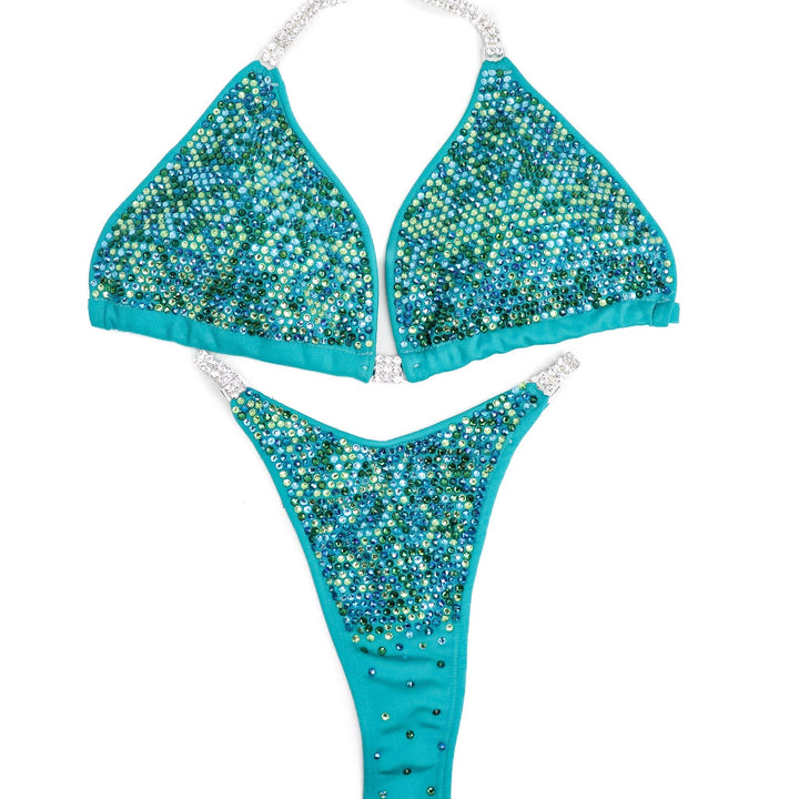 Dive into the spotlight with Seafoam Aqua Radiance! 🌊💎 This aqua jade suit is adorned with mesmerizing green and blue crystals, creating a stunning blend of colors that guarantees to make you stand out on stage. Elevate your presence and performance with this exquisite masterpiece. 💪✨ #BodybuildingFashion #SeafoamAquaRadiance #FitnessCompetition