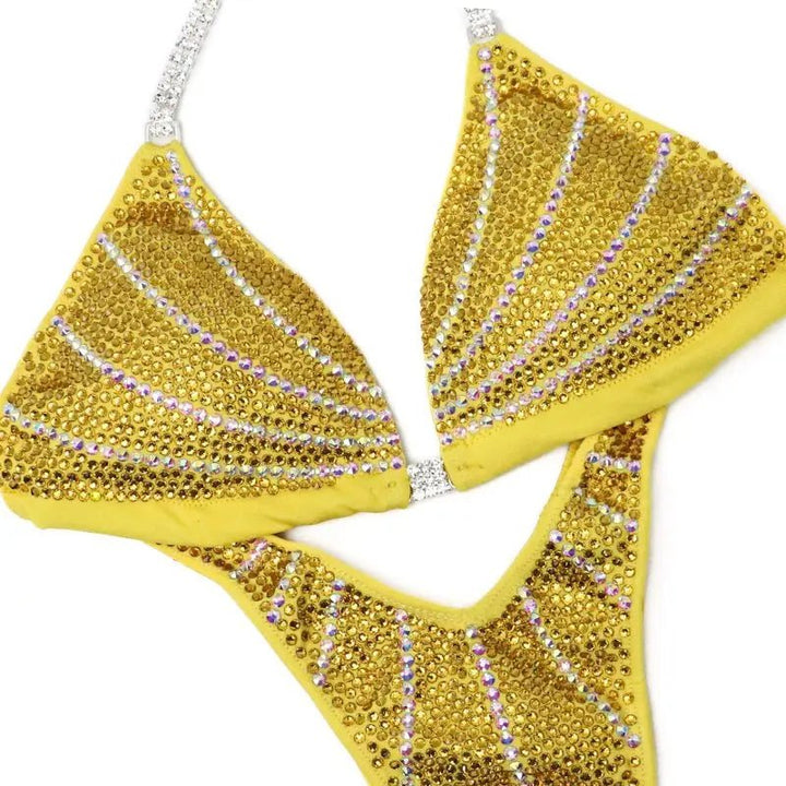Yellow crystal-studded bikini with curved iridescent lines creating a sparkling galaxy design on fabric
