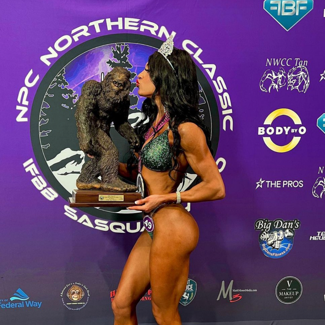 Introducing Ashley's Grasshopper Nova, a stunning replica of Ashley Kaltwasser's suit at the NPC Northern Classic IFBB Sasquatch. Featuring mesmerizing emerald and green hues, this suit ensures you shine like a champion on stage. Elevate your presence with its striking design, a true standout for competitors.