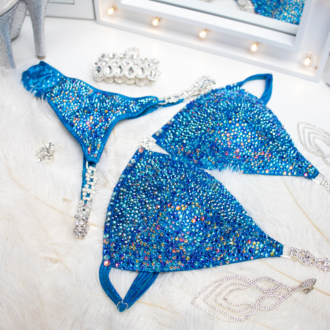 "Introducing Isa's Aquamarine Dream Radiance: The ultimate suit to illuminate your stage presence. Designed to bring out confidence in all female bodybuilders, this ensemble shines with regal elegance, empowering you to own the spotlight with grace and power. 💎✨ #FemaleBodybuilding #StageConfidence"